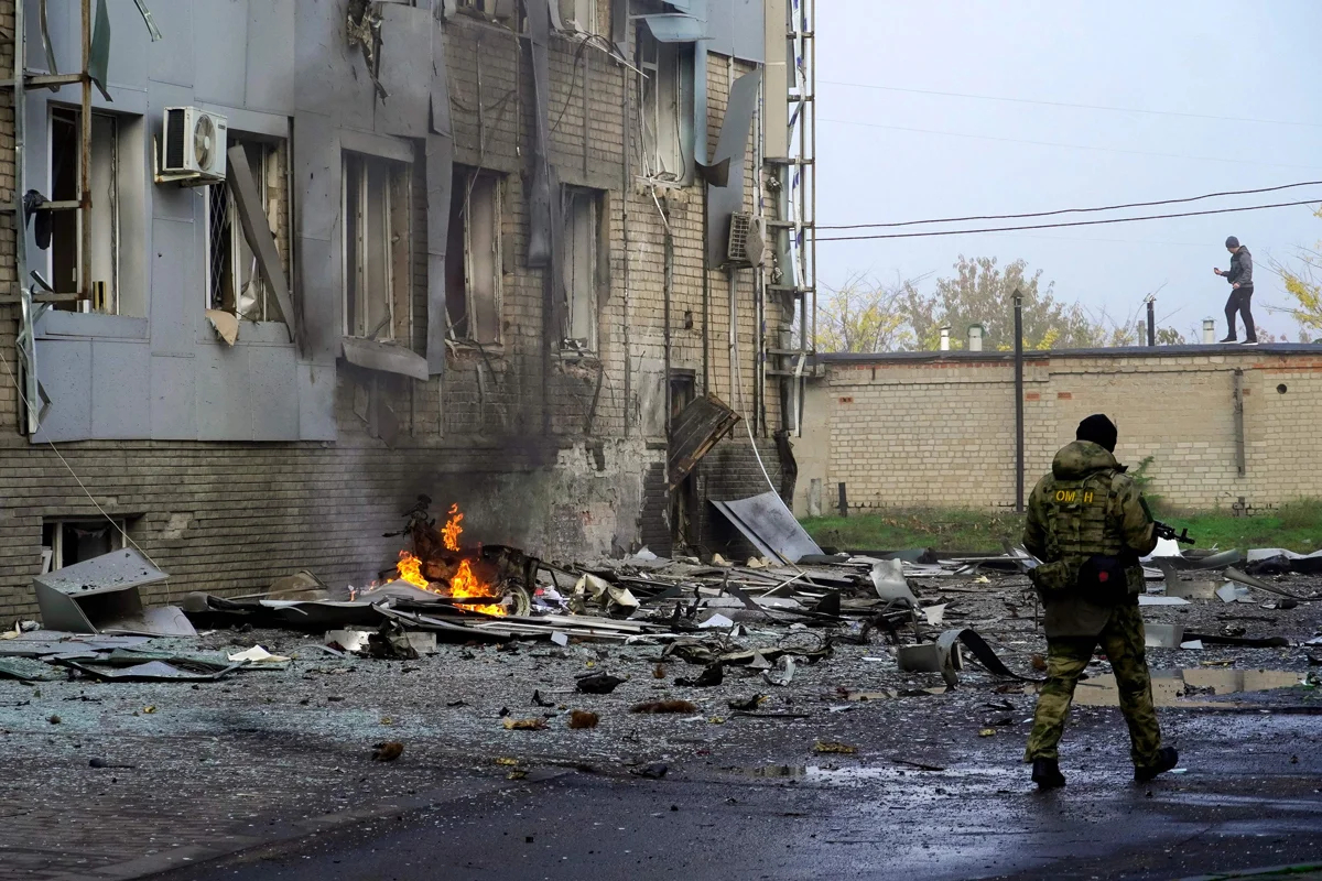 Российский ОМОНовец охраняет место взрыва заминированного автомобиля у здания, где размещается местный телеканал, Мелитополь, 25 октября 2022 года. Фото: AFP / Scanpix / LETA