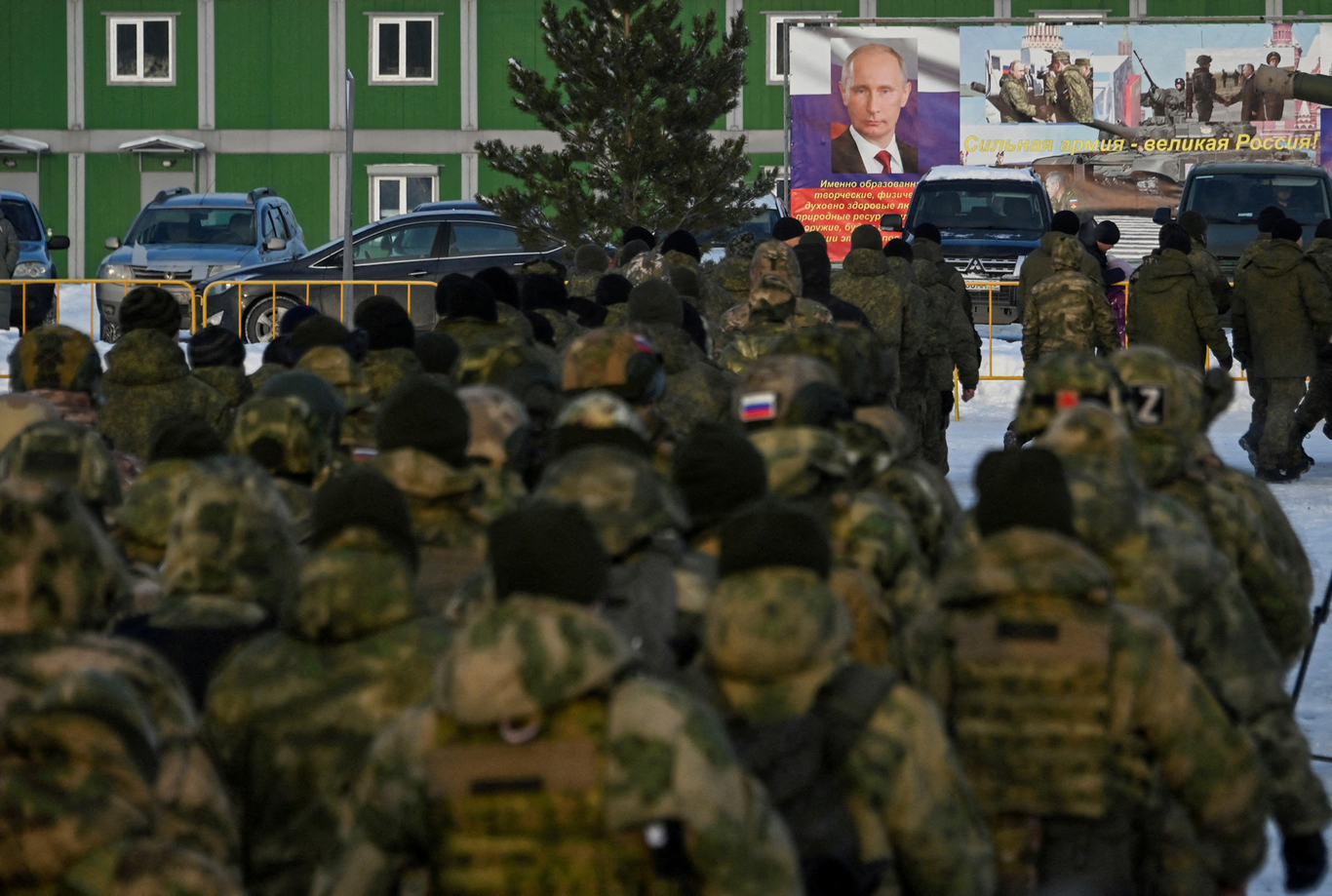 Российские резервисты, призванные в ходе мобилизации войск, идут к баннеру с портретом Владимира Путина. Омск. 6 января 2023 года. Фото: Алексей Мальгавко / Reuters / Scanpix / LETA