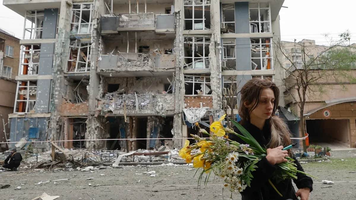 A woman walks past a residential building struck by a drone as a result of an overnight strike in Kyiv, Ukraine, 25 May 2025. Photo: EPA-EFE/SERGEY DOLZHENKO