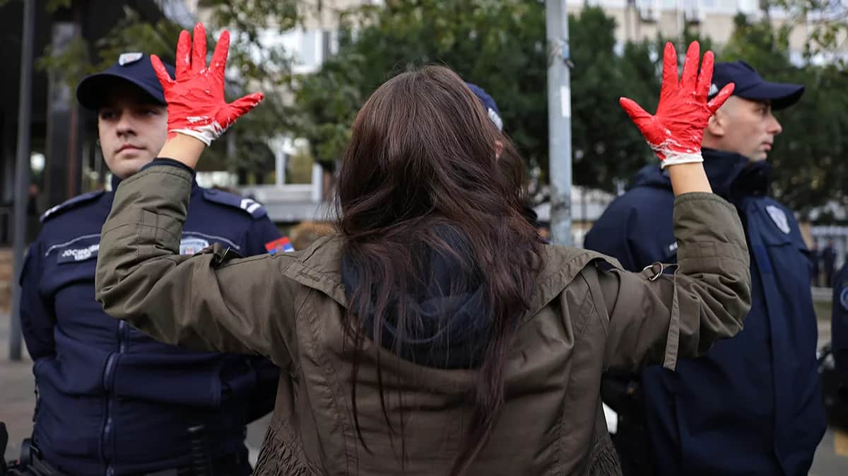 Участница акции в поддержку жертв обрушения навеса на железнодорожном вокзале Нови-Сад в Белграде, Сербия, 3 ноября 2024 года. Фото: Andrej Cukic / EPA-EFE