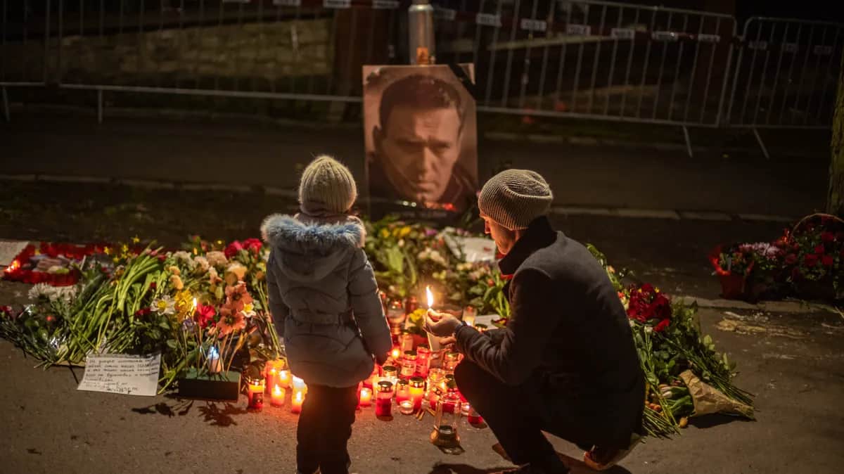 A man lights a candle in memory of Alexey Navalny outside the Russian embassy in Prague, 1 March 2024. Photo: EPA-EFE/MARTIN DIVISEK