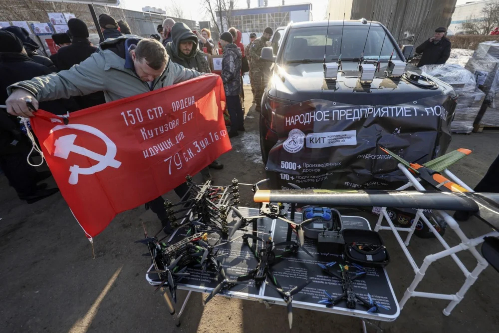 A Russian Communist Party supporter holds a Soviet-era military flag at a military aid collection point near Moscow, Russia, 26 February 2025. Photo: EPA-EFE/SERGEI ILNITSKY