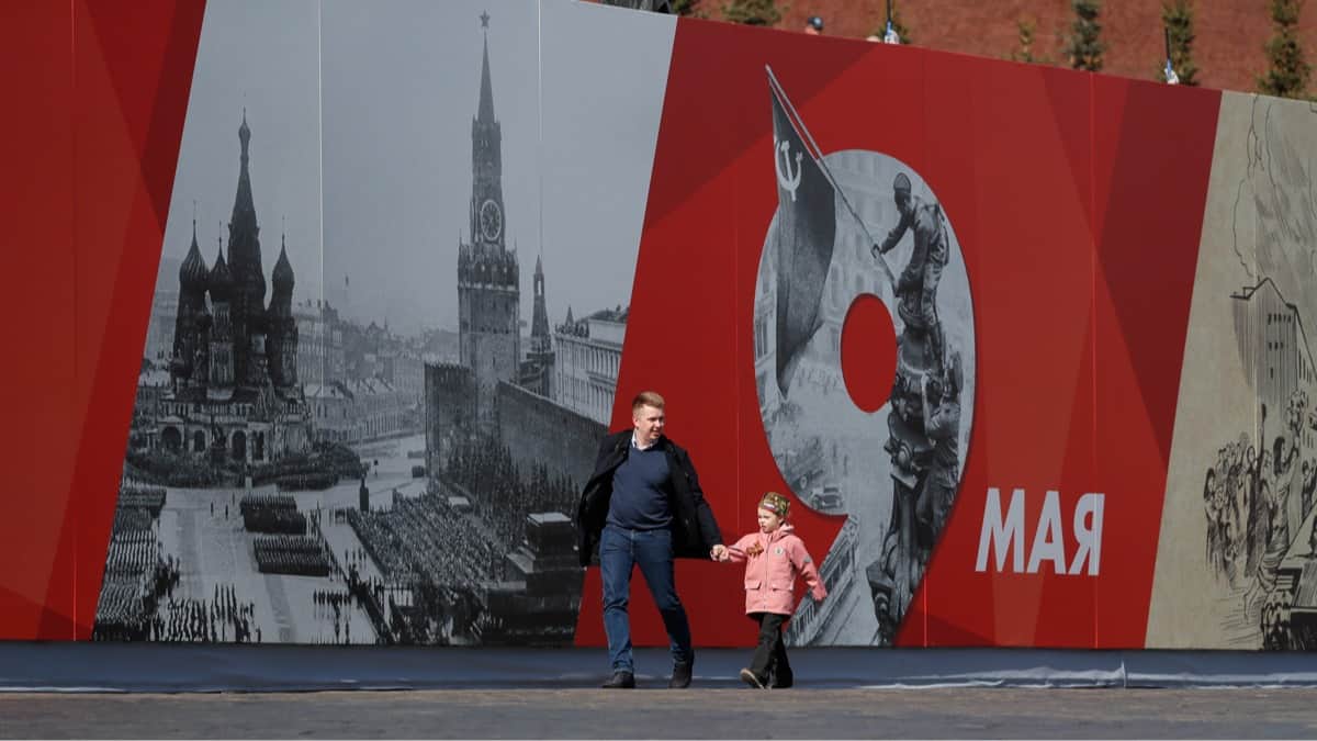 Мужчина с ребенком идут по центру Москвы в преддверии генеральной репетиции военного парада на Красной площади, 7 мая 2022 года. Фото: Юрий Кочетков / EPA