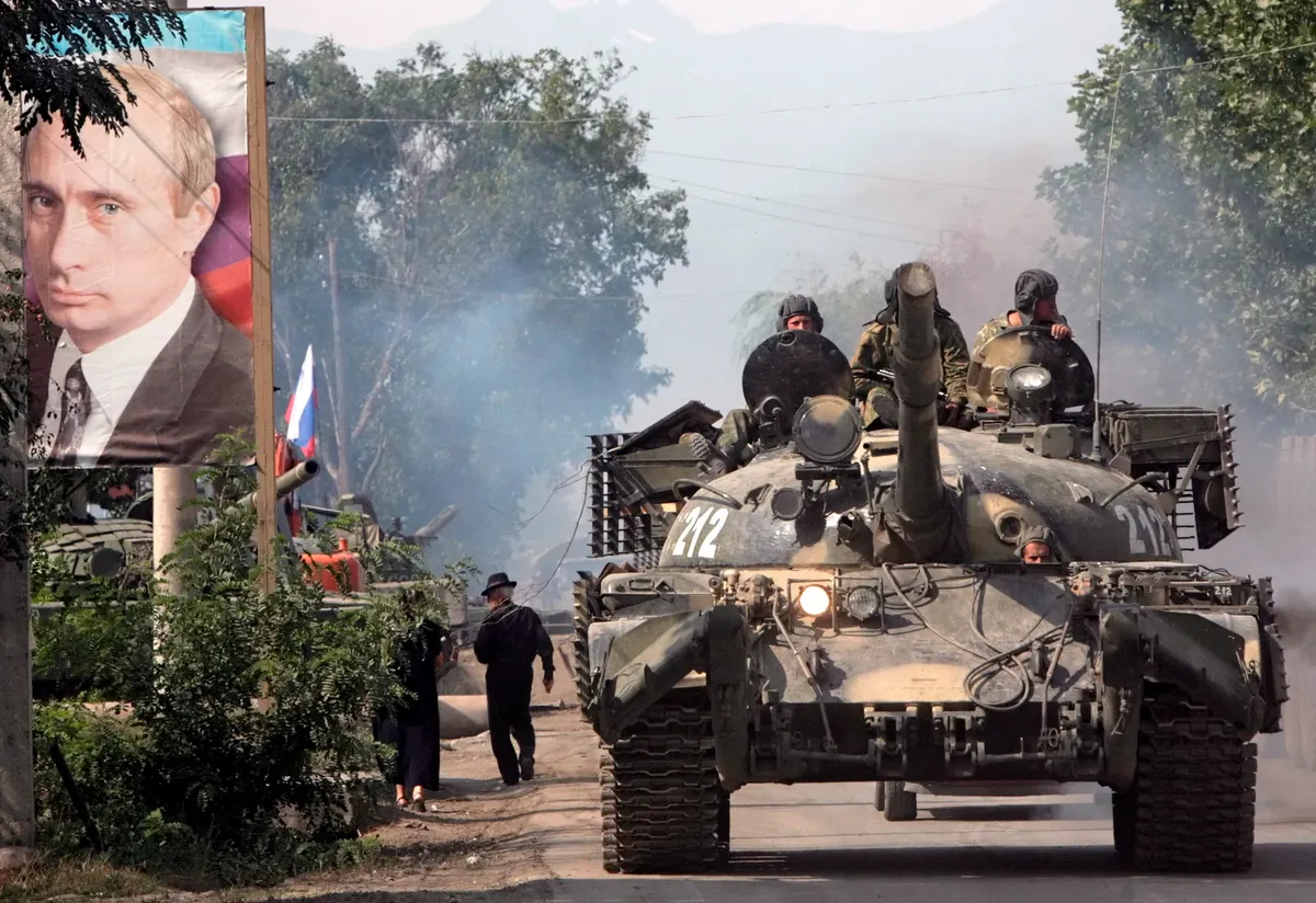 A Russian tank passes a portrait Vladimir Putin as it drives through Tskhinvali, South Ossetia on 20 August 2008. Photo: EPA / MAXIM SHIPENKOV