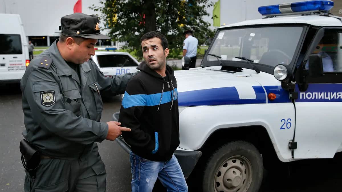 An alleged illegal migrant is detained by police during a raid in the outskirts of Moscow. Photo: EPA/YURI KOCHETKOV