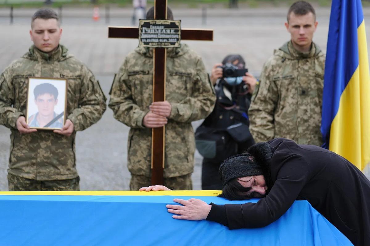 Photo: A grieving mother hugs the coffin of a Ukrainian serviceman killed in action. EPA-EFE/MYKOLA TYS