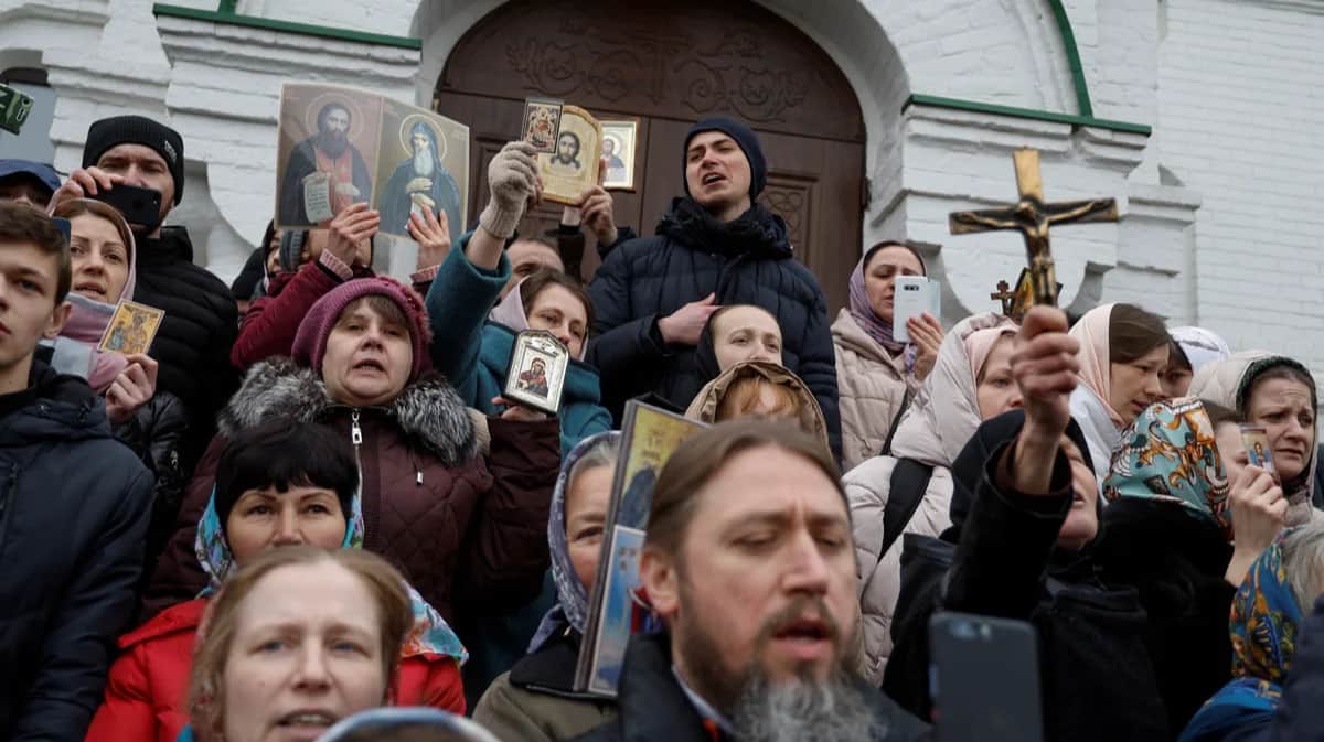 Последователи Украинской православной церкви, обвиняемой в связях с Москвой, молятся, блокируя вход в церковь на территории Киево-Печерской лавры, 31 марта 2023 года. Фото: Валентин Огиренко / Reuters / Scanpix / LETA