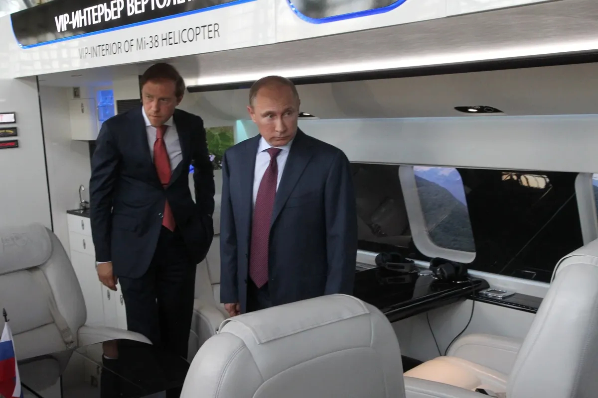Denis Manturov and Vladimir Putin inspect the cabin of a new Mi-38 helicopter during a visit to a helicopter plant. Photo: Sasha Mordovets / Getty Images