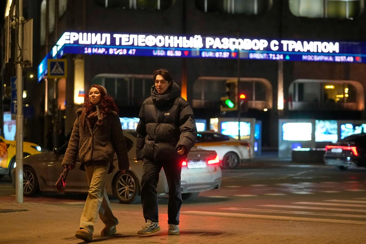Прохожие на фоне бегущей строки о звонке Владимира Путина и Дональда Трампа, Москва, 18 марта 2025 года. Фото: Павел Бедняков / AP Photo / Scanpix / LETA