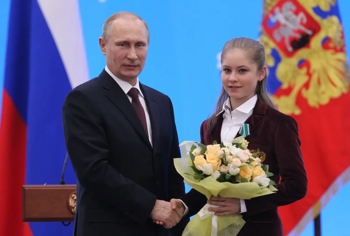 Владимир Путин и олимпийская чемпионка Юлия Липницкая во время церемонии награждения российских спортсменов-олимпийцев, 24 февраля 2014 года, Сочи. Фото: Sasha Mordovets / Getty Images