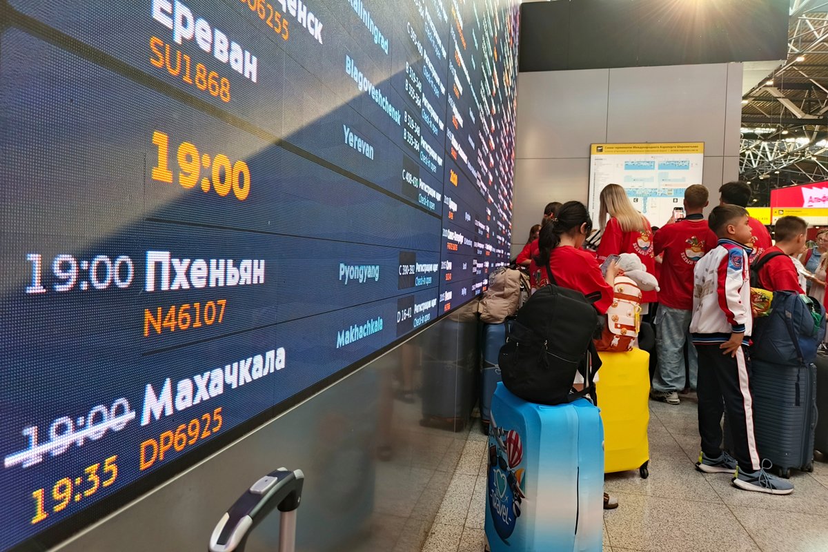 Пассажиры у табло, показывающим время вылета самолёта в Пхеньян в московском аэропорту Шереметьево, 27 июля 2025 года. Фото: AP Photo / Scanpix / LETA