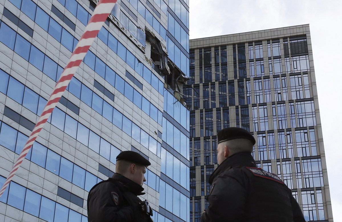 Полицейские стоят перед повреждённым зданием после атаки дронов в Москве, 30 июля 2023 года. Фото: Юрий Кочетков / EPA